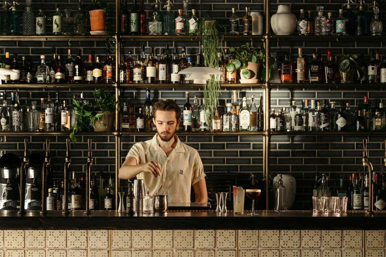 a man standing behind a counter in a bar at The Hoxton, Southwark in London